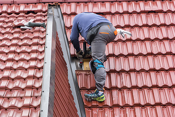 Image showing Roofer repair  the roof of clay tiles