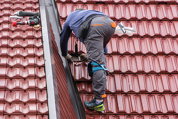 Image showing Roofer repair  the roof of clay tiles
