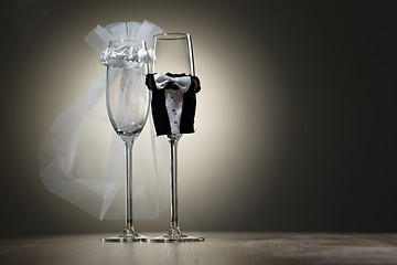 Image showing Two empty wineglass dressed in veil and wedding tuxedo