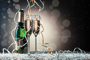 Image showing Champagne bottle and two wineglasses on table covered snow