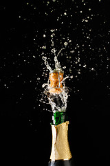 Image showing Cork flies out of champagne bottle. Festive theme