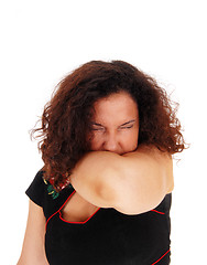 Image showing Sneezing woman with arm over mouth.