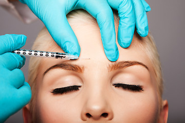 Image showing Cosmetic plastic surgeon injecting aesthetics face