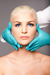 Image showing Cosmetic plastic surgeon touching aesthetics face