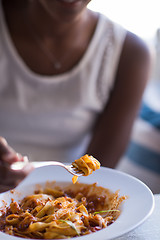 Image showing a young African American woman eating pasta