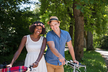 Image showing Young multiethnic couple having a bike ride in nature