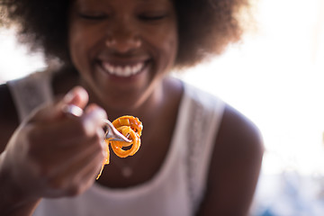 Image showing a young African American woman eating pasta