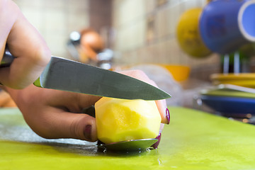 Image showing Cook slices potato