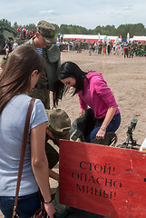 Image showing Girl - visitor of show puts on sapper suit