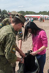 Image showing Girl - visitor of show puts on sapper suit