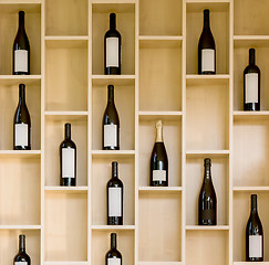 Image showing variety bottles of wine and champagne in a wooden display case in the store