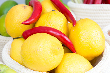 Image showing lemons and chili peppers in a wicker basket close-up