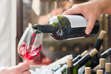 Image showing red wine being poured into a glass close-up