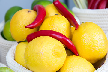 Image showing lemons and chili peppers in a wicker basket close-up