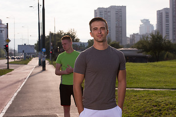 Image showing Two young men jogging through the city