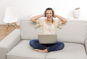 Image showing Listen music on her laptop