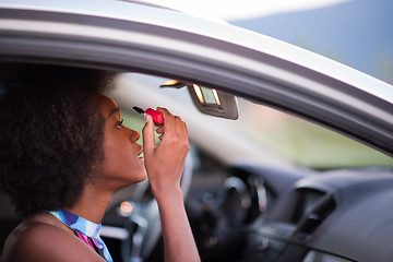 Image showing a young African-American woman makeup in the car