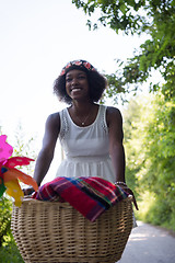 Image showing pretty young african american woman riding a bike in forest