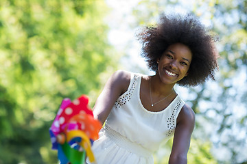 Image showing pretty young african american woman riding a bike in forest