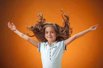 Image showing The cute cheerful little girl on orange background