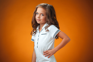 Image showing The cute cheerful little girl on orange background