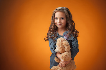 Image showing The cute cheerful little girl on orange background