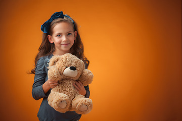 Image showing The cute cheerful little girl on orange background