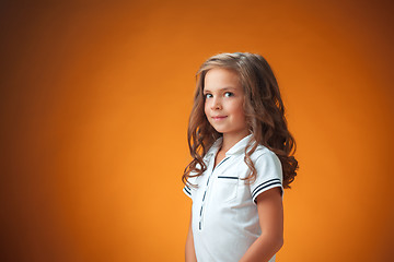 Image showing The cute cheerful little girl on orange background