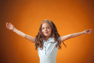 Image showing The cute cheerful little girl on orange background