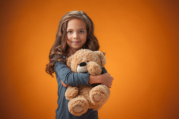 Image showing The cute cheerful little girl on orange background