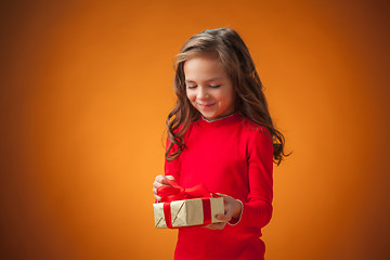 Image showing The cute cheerful little girl on orange background