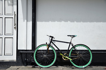 Image showing Bicycle leaning and white painted brick wall