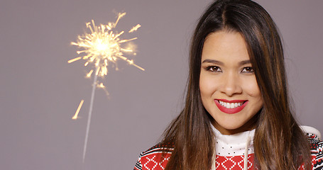 Image showing Young woman celebrating Christmas with a sparkler