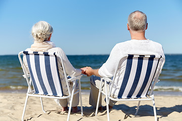 Image showing senior couple sitting on chairs at summer beach