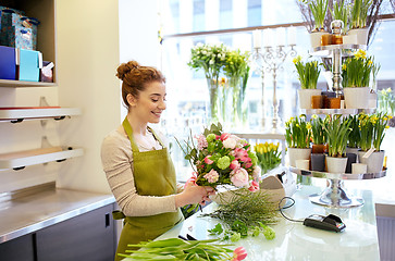 Image showing smiling florist woman making bunch at flower shop