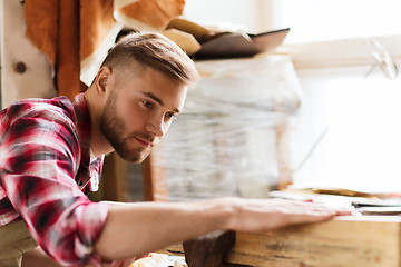 Image showing carpenter working with wood plank at workshop