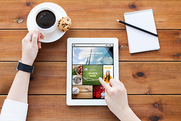 Image showing close up of woman with tablet pc on wooden table