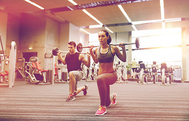 Image showing young man and woman training with barbell in gym