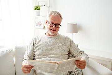 Image showing senior man in glasses reading newspaper at home