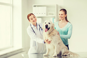 Image showing happy woman with dog and doctor at vet clinic