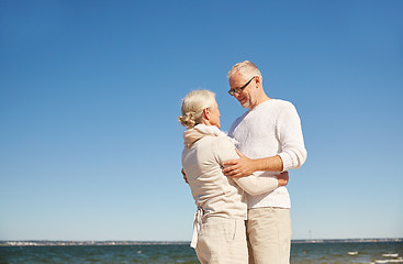 Image showing happy senior couple hugging on summer beach