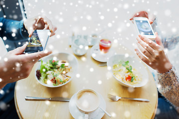 Image showing close up of couple picturing food by smartphone