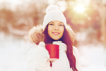 Image showing happy young woman with tea cup outdoors in winter