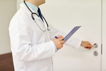 Image showing close up of doctor with clipboard at hospital door