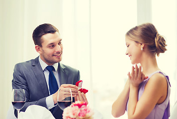 Image showing man proposing to his girlfriend at restaurant