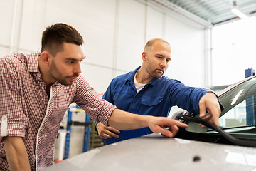 Image showing auto mechanic with clipboard and man at car shop