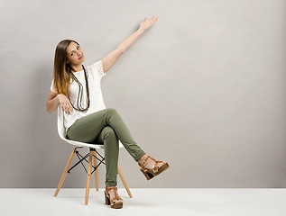 Image showing Woman pointing to the wall