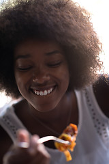 Image showing a young African American woman eating pasta