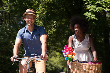 Image showing Young multiethnic couple having a bike ride in nature