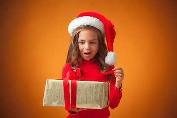 Image showing The cute cheerful little girl on orange background